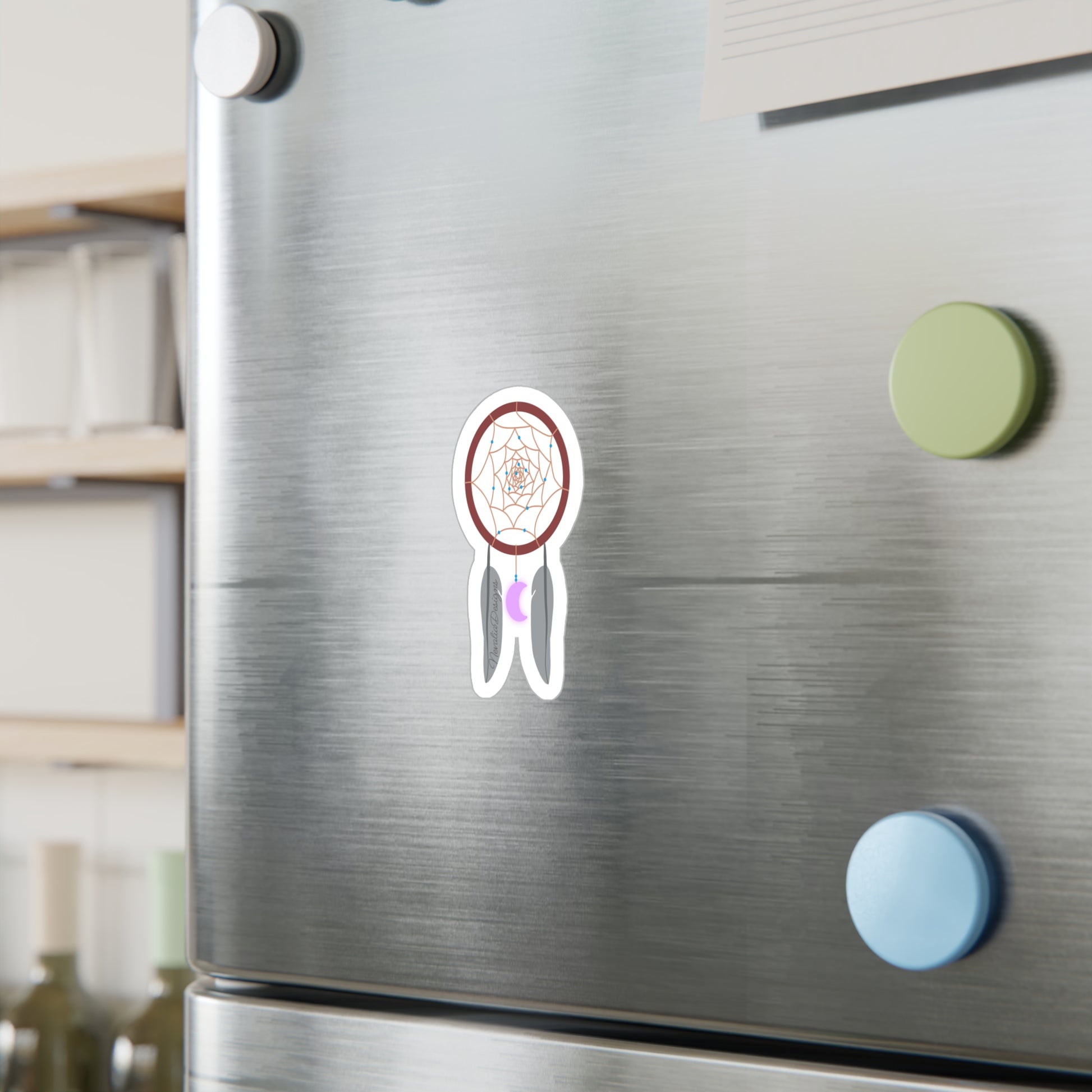 dreamcatcher sticker on a metallic fridge surface with colorful magnets.