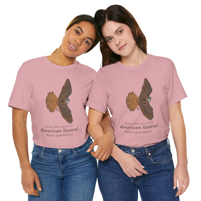 Two dark haired woman wearing pink t-shirts with an American kestrel illustration and text on a white background