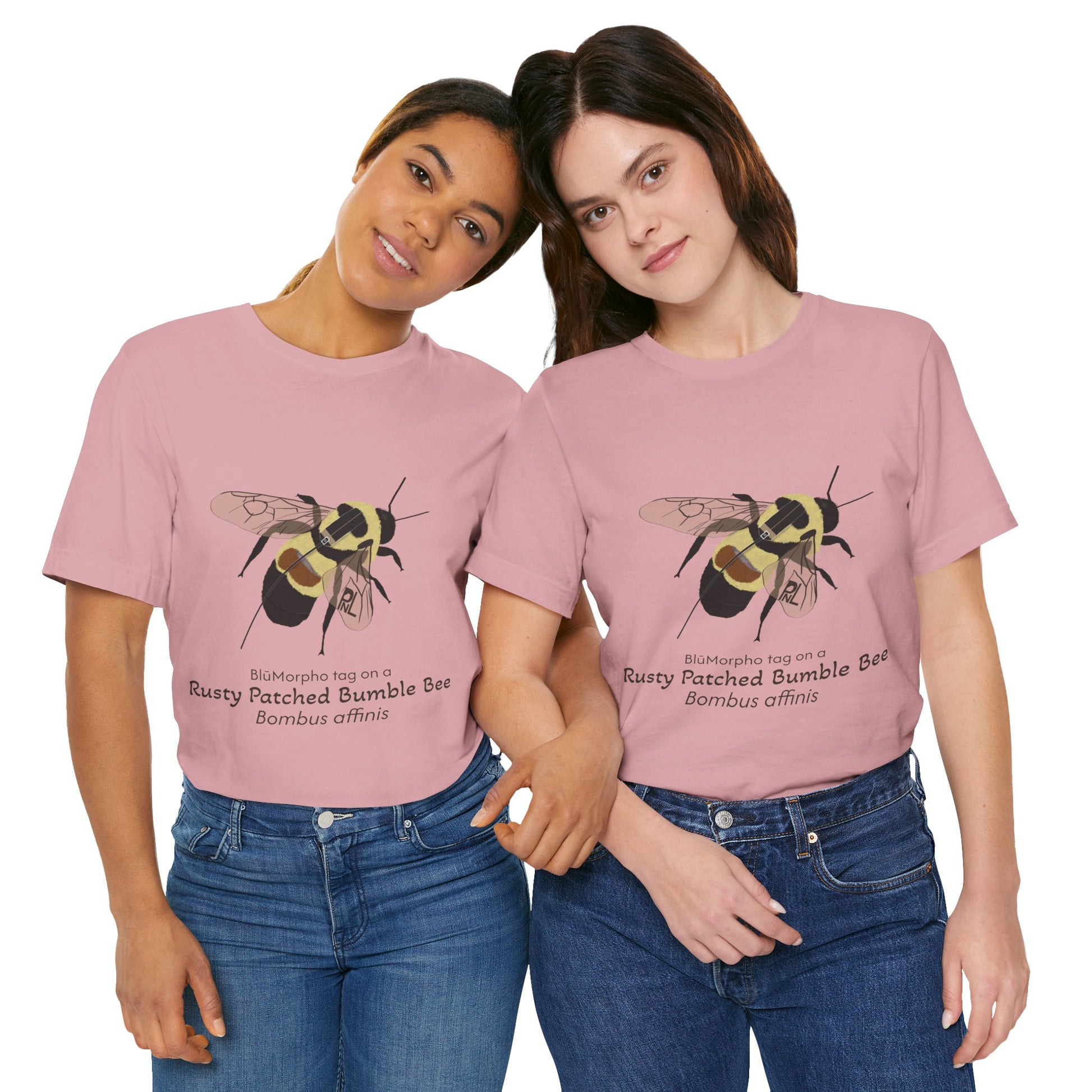 Two dark haired women wearing light pink t-shirts with a rusty patched bumble bee illustration and text on a white background