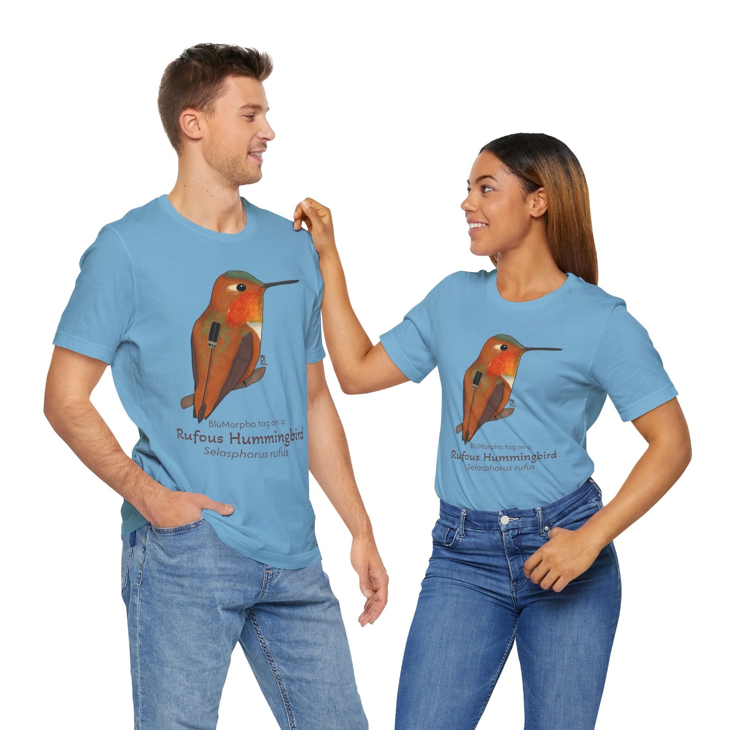 A dark haired man and woman standing together while wearing blue t-shirts with a Rufous Hummingbird illustration and text  on a white background