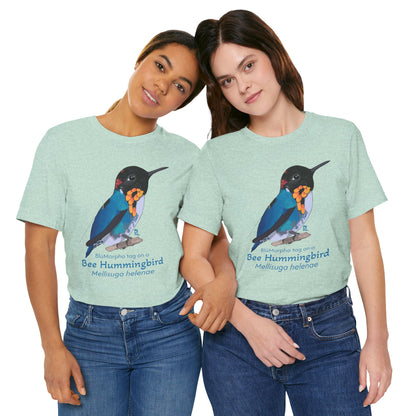 Two dark haired women wearing light green t-shirts with a colorful bee hummingbird illustration and text on a white background